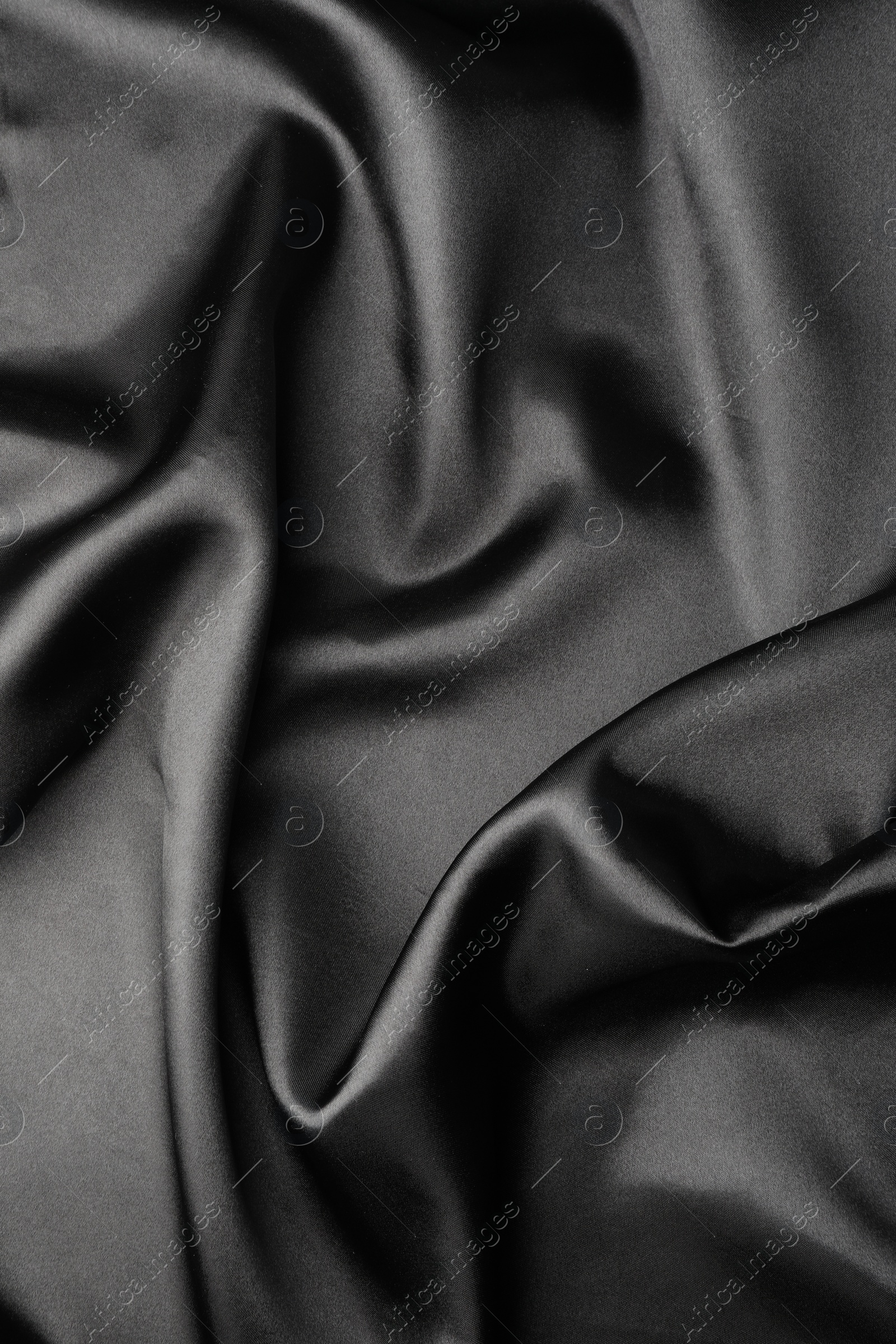 Photo of Crumpled black silk fabric as background, top view