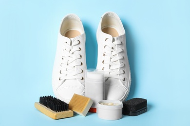 Photo of Composition with stylish footwear and shoe care accessories on light blue background