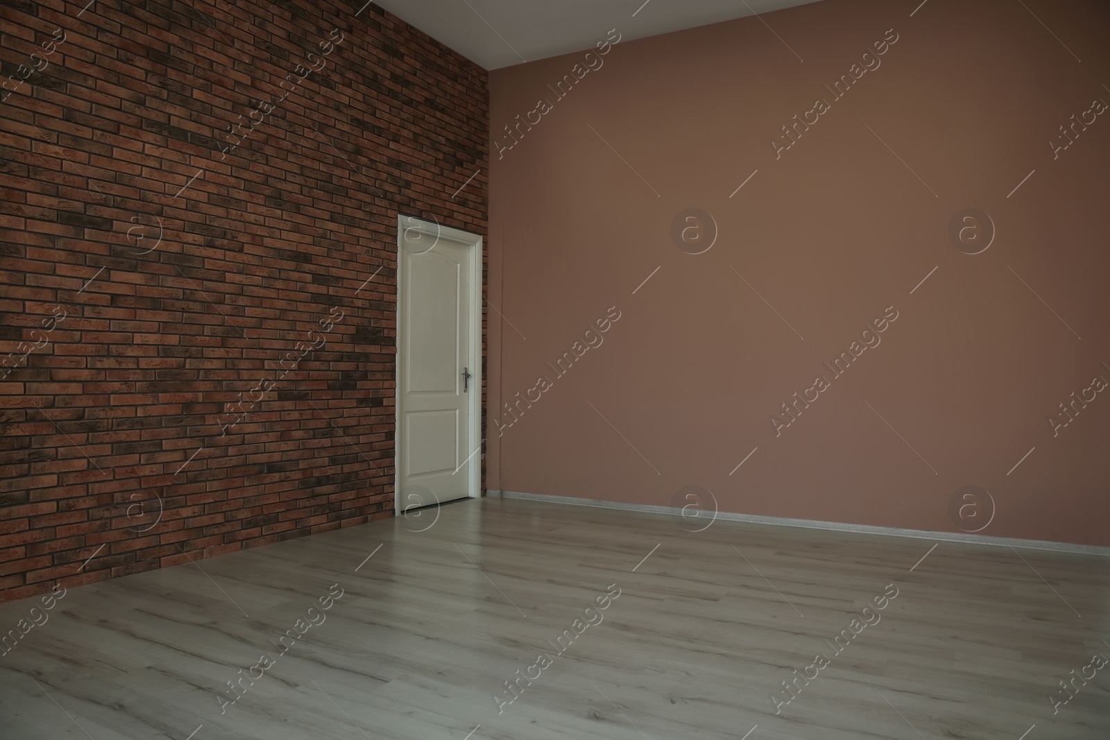 Photo of Empty room with different walls, white door and wooden floor