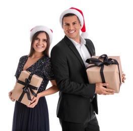 Photo of Beautiful happy couple in Santa hats holding Christmas gifts on white background
