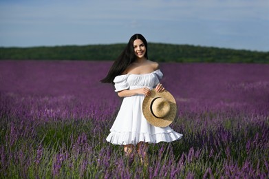 Photo of Beautiful young woman walking in lavender field