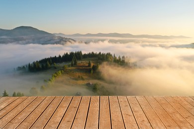 Empty wooden surface, beautiful landscape with thick mist and forest in mountains