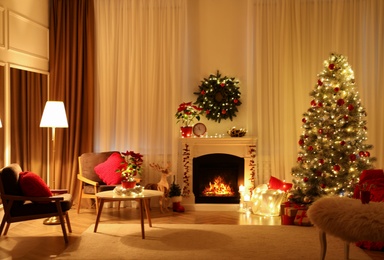 Beautiful living room interior with burning fireplace and Christmas tree in evening