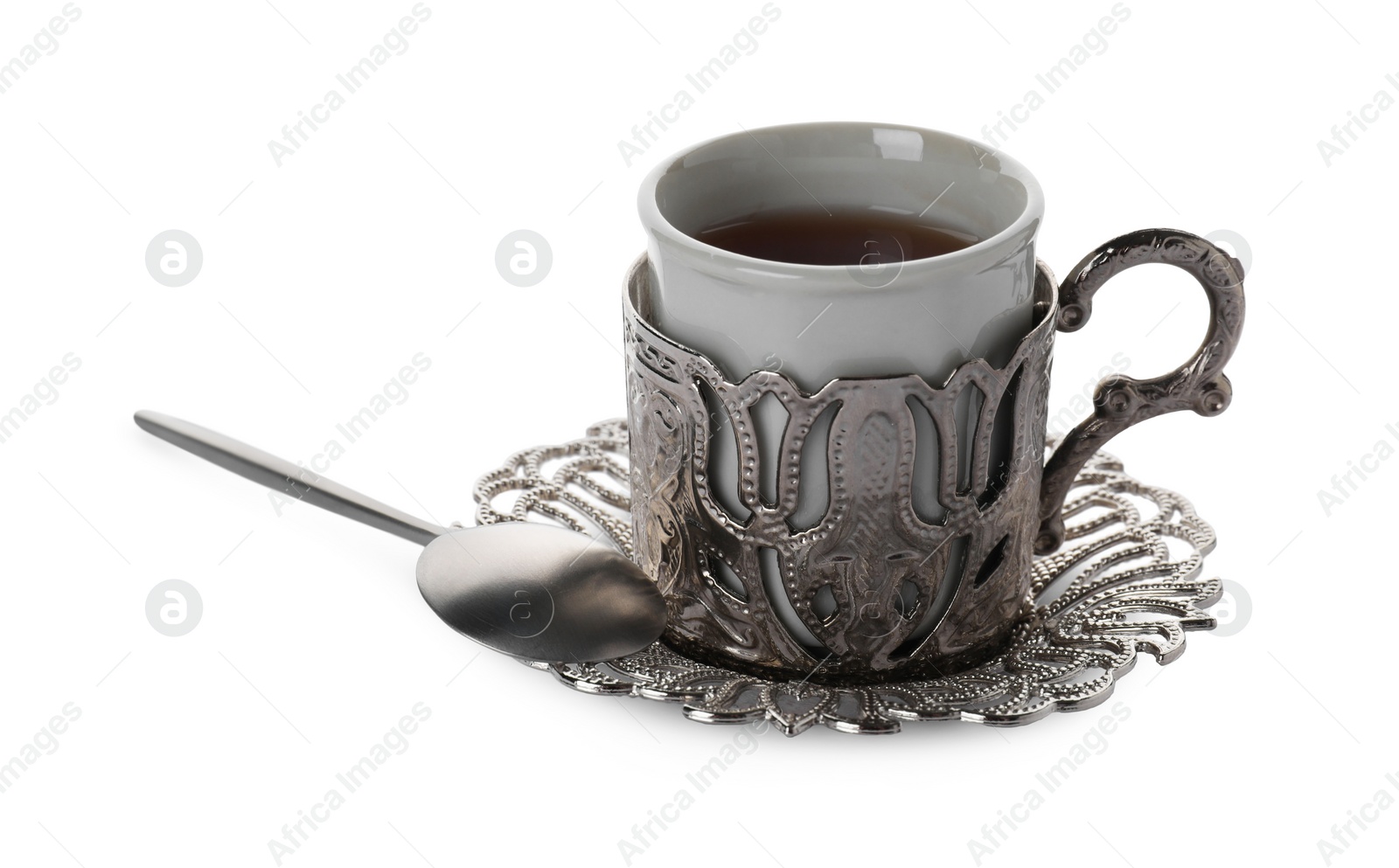 Photo of Glass of traditional Turkish tea in vintage holder isolated on white