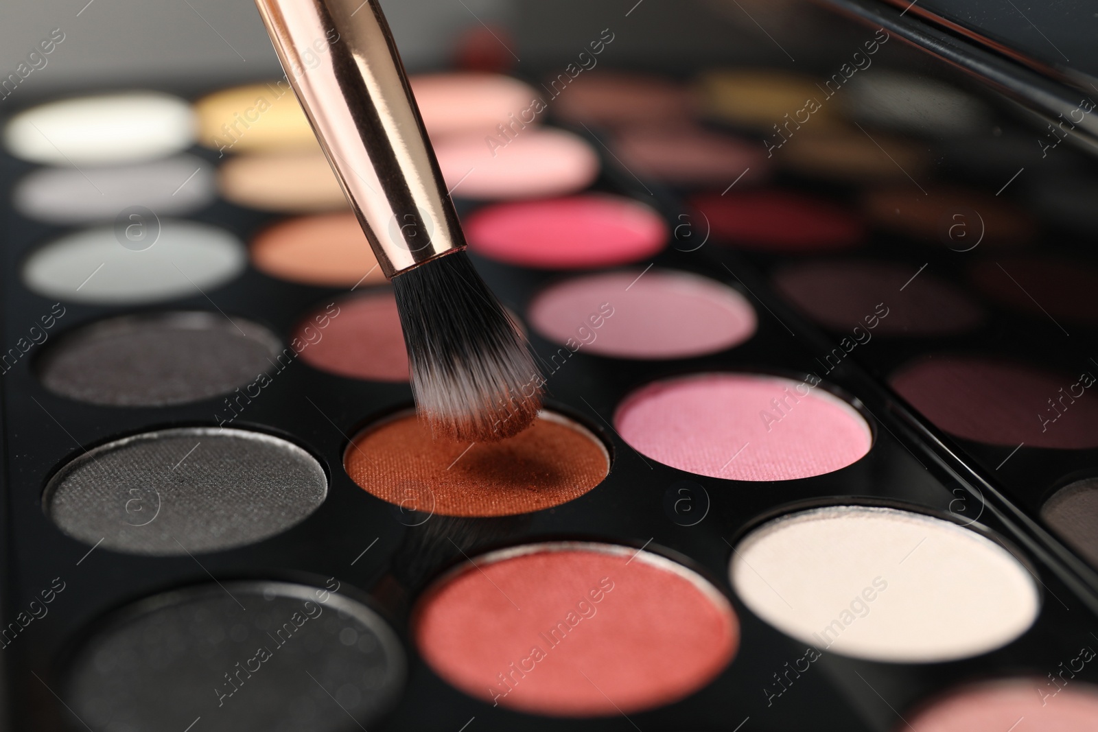 Photo of Colorful eyeshadow palette with brush, closeup view