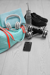 Sports bag and gym stuff on wooden floor