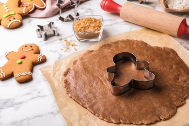 Making homemade gingerbread man cookies and cutter on white marble table