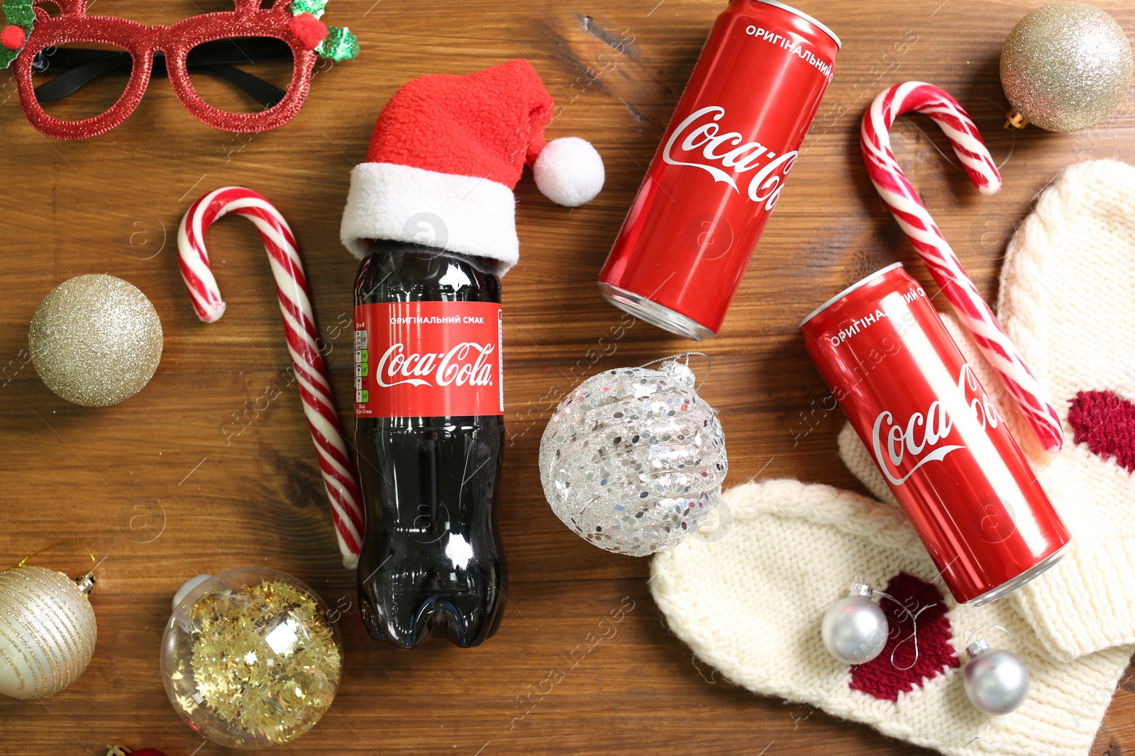 Photo of MYKOLAIV, UKRAINE - January 01, 2021: Flat lay composition with Coca-Cola drinks and Christmas decorations on wooden background