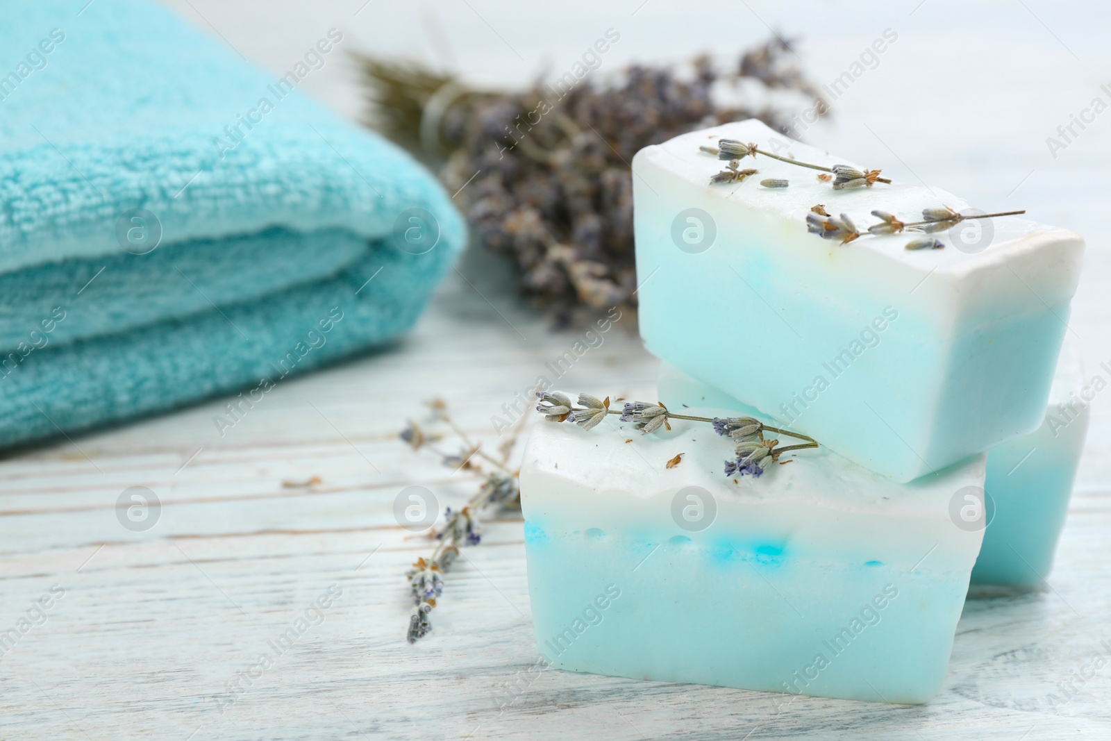 Photo of Natural handmade soap bars on white wooden table, closeup. Space for text