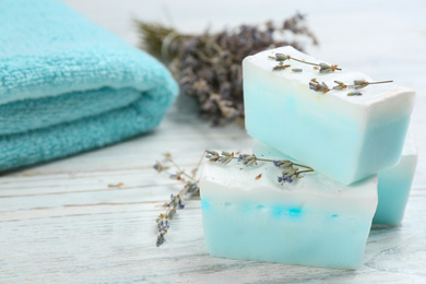 Photo of Natural handmade soap bars on white wooden table, closeup. Space for text