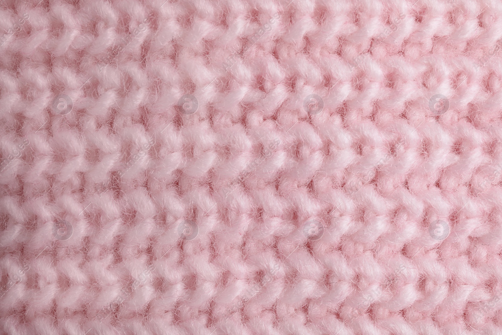 Photo of Pink knitted sweater as background, closeup view