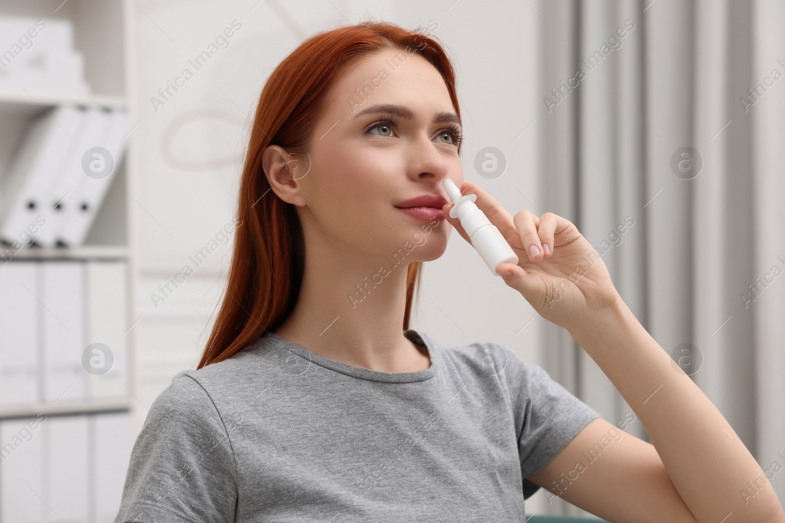 Photo of Medical drops. Woman using nasal spray at home