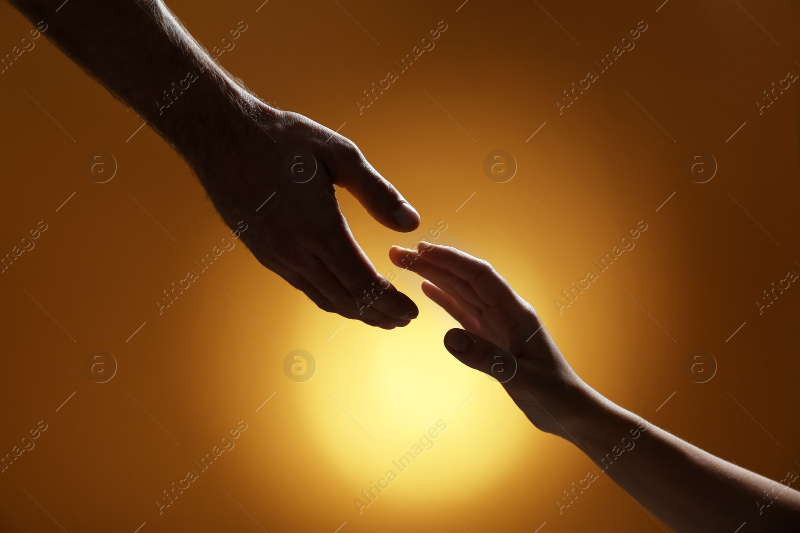 Photo of Man reaching for woman's hand on color background, closeup. Help and support concept