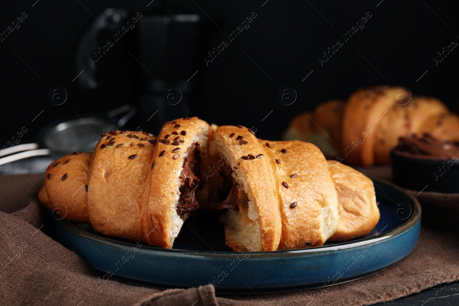 Photo of Tasty croissant with chocolate and sesame seeds on table. Space for text