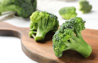 Photo of Board with fresh green broccoli on table, closeup