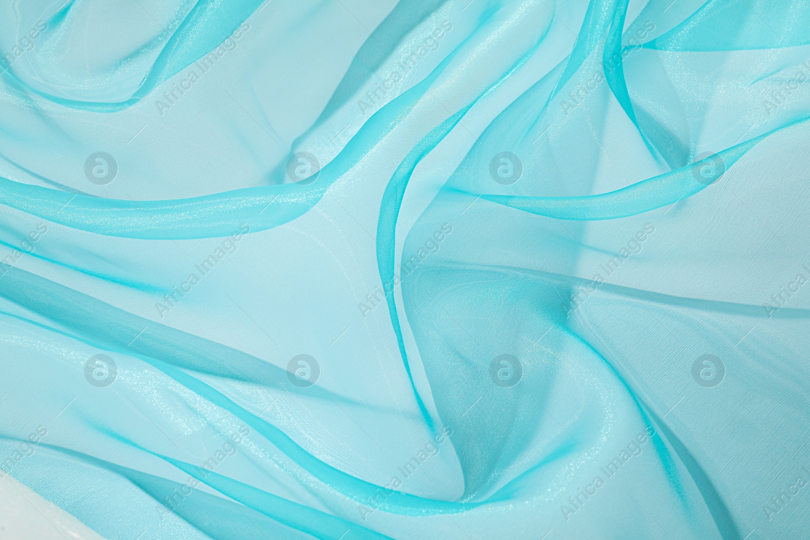 Photo of Beautiful turquoise tulle fabric as background, closeup