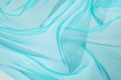 Beautiful turquoise tulle fabric as background, closeup