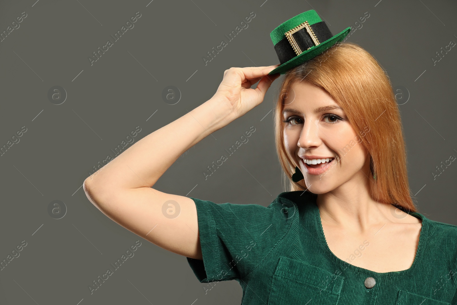 Photo of Young woman with green leprechaun hat on grey background. St. Patrick's Day celebration