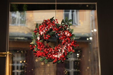 Beautiful Christmas wreath hanging on glass door