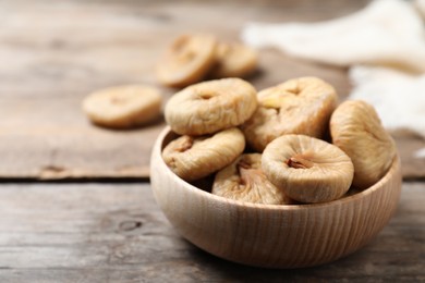 Photo of Tasty dried figs in bowl on wooden table