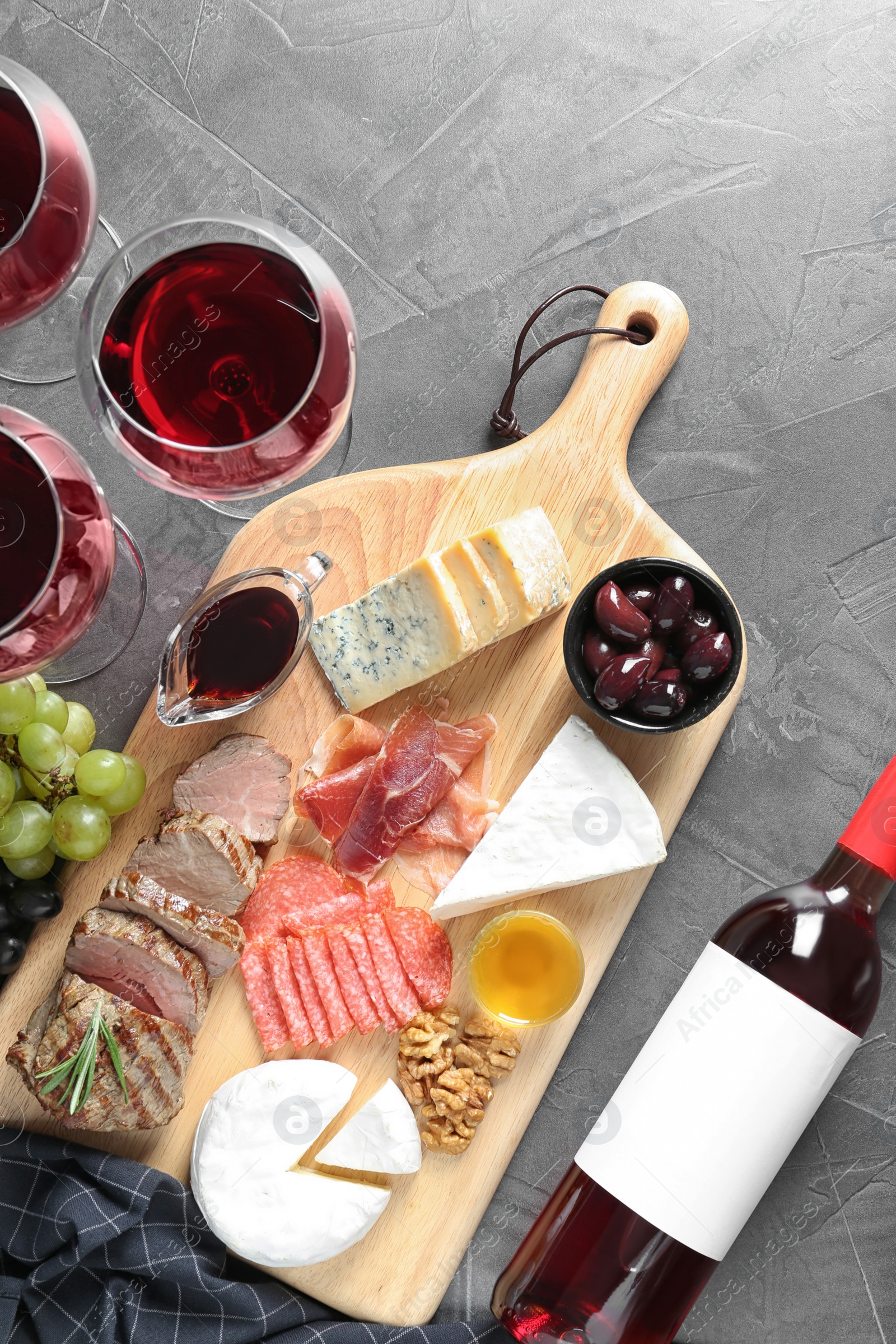 Photo of Flat lay composition with wine and snacks on grey background