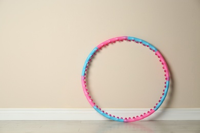 Photo of Hula hoop near beige wall in gym. Space for text