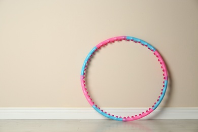 Hula hoop near beige wall in gym. Space for text