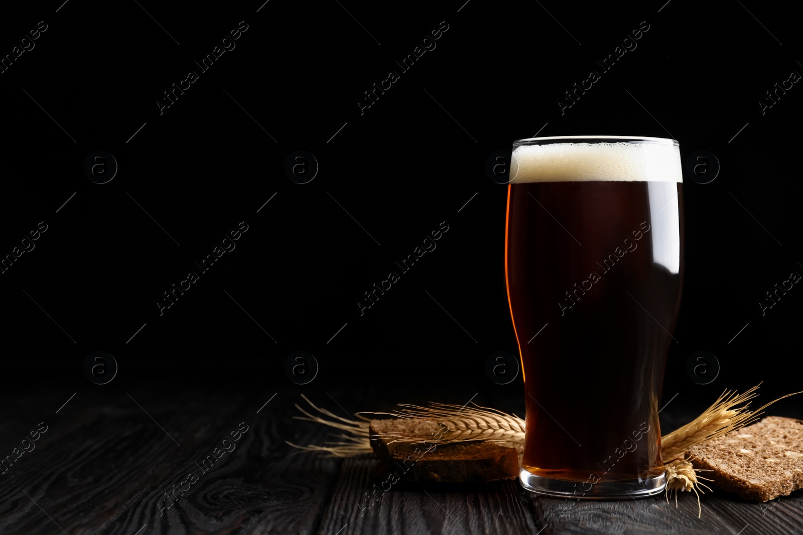 Photo of Delicious kvass, bread and spikes on wooden table. Space for text