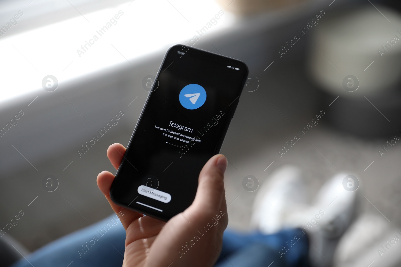 Photo of MYKOLAIV, UKRAINE - MARCH 16, 2020: Man holding iPhone 11 with Telegram app on screen indoors, closeup