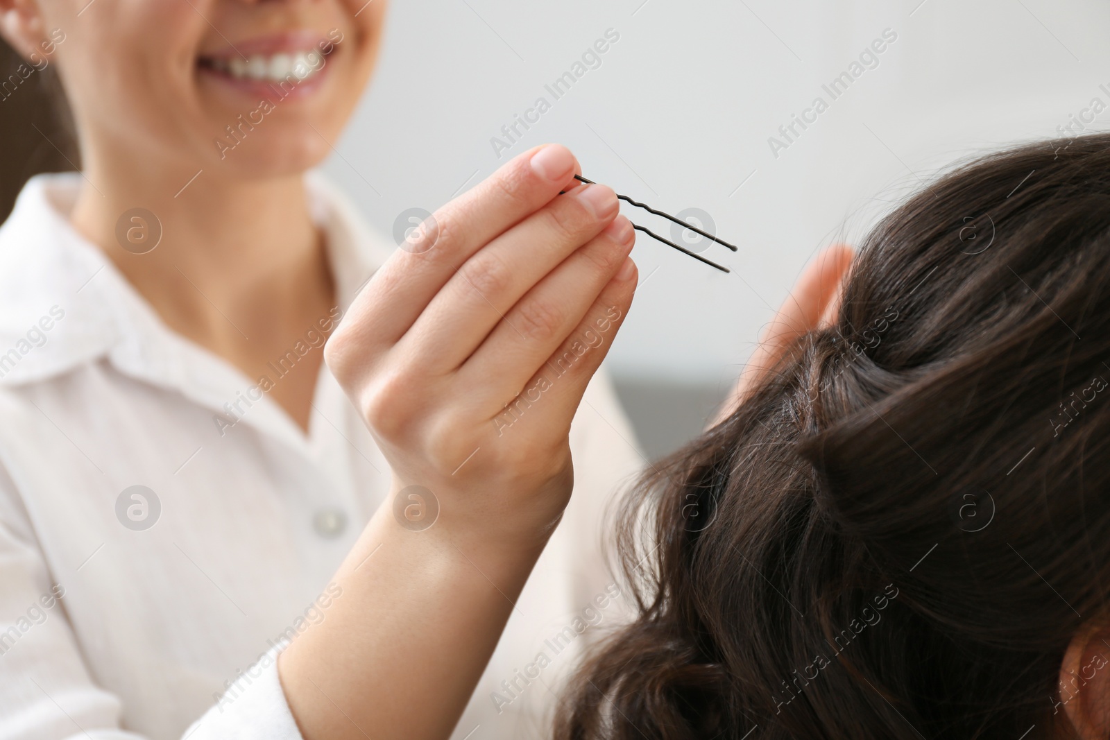 Photo of Stylist working with client in salon, making hairstyle