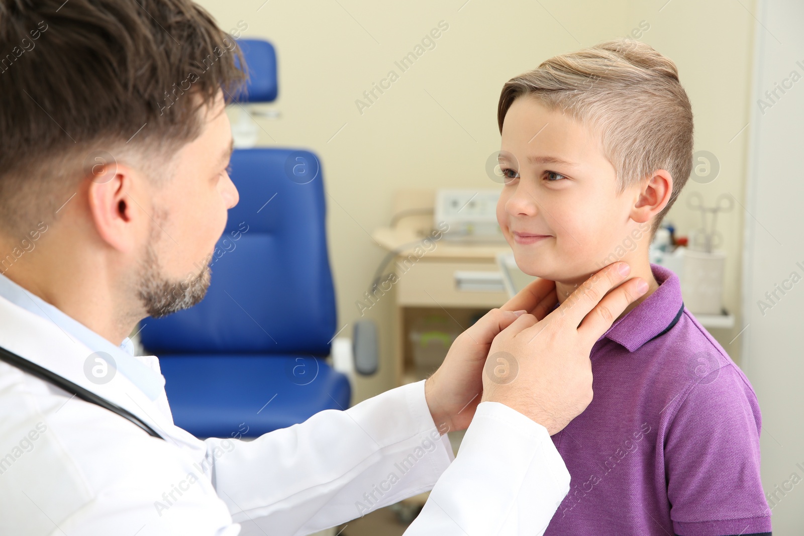 Photo of Male otolaryngologist examining little child in hospital