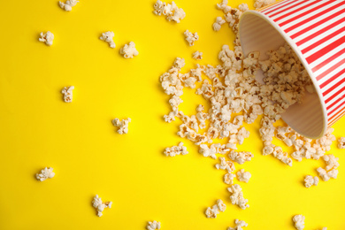 Photo of Tasty pop corn on yellow background, flat lay