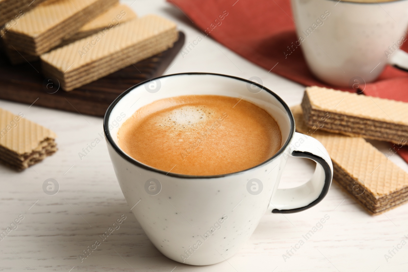 Photo of Delicious coffee and wafers for breakfast on white wooden table