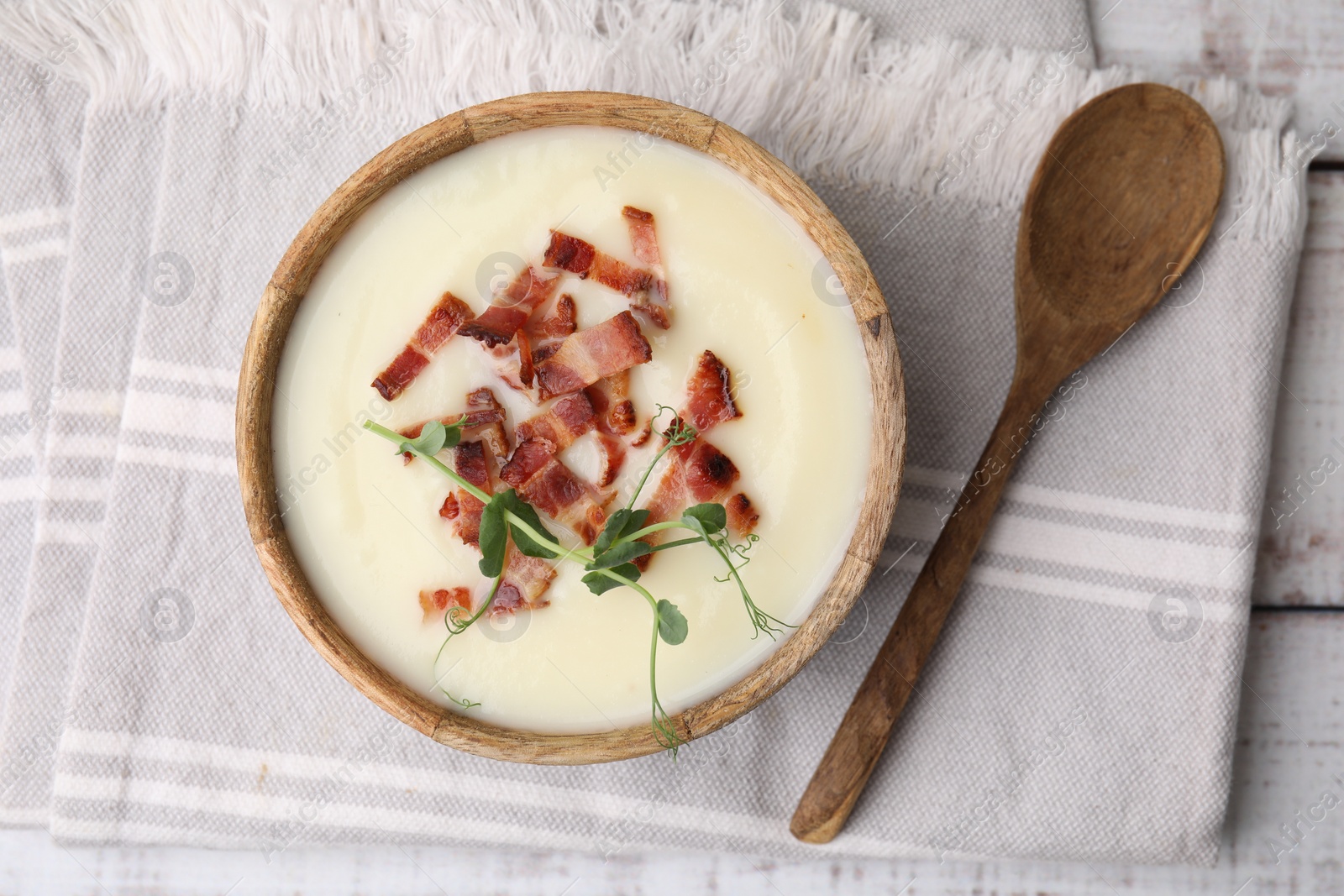 Photo of Delicious potato soup with bacon and microgreens in bowl served on table, flat lay