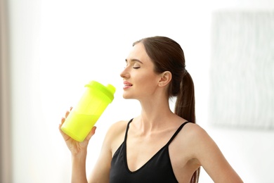 Photo of Athletic young woman drinking protein shake at home