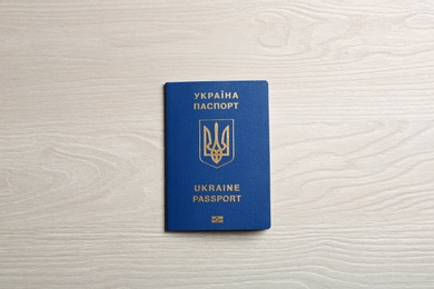 Photo of Ukrainian travel passport on wooden background, top view. International relationships