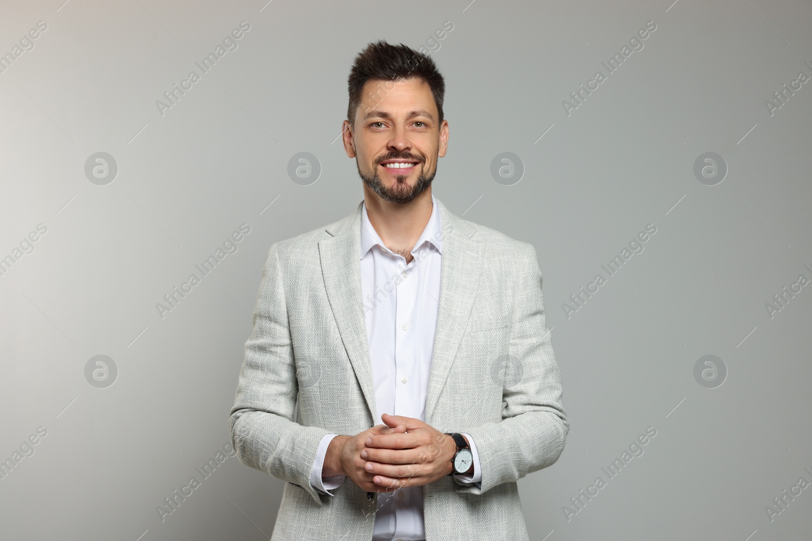 Photo of Happy teacher in light suit against beige background