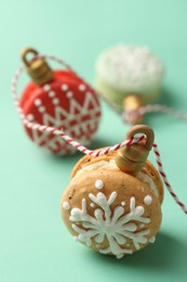 Photo of Beautifully decorated Christmas macarons with rope on turquoise background, closeup