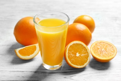 Photo of Glass of orange juice and fresh fruits on table