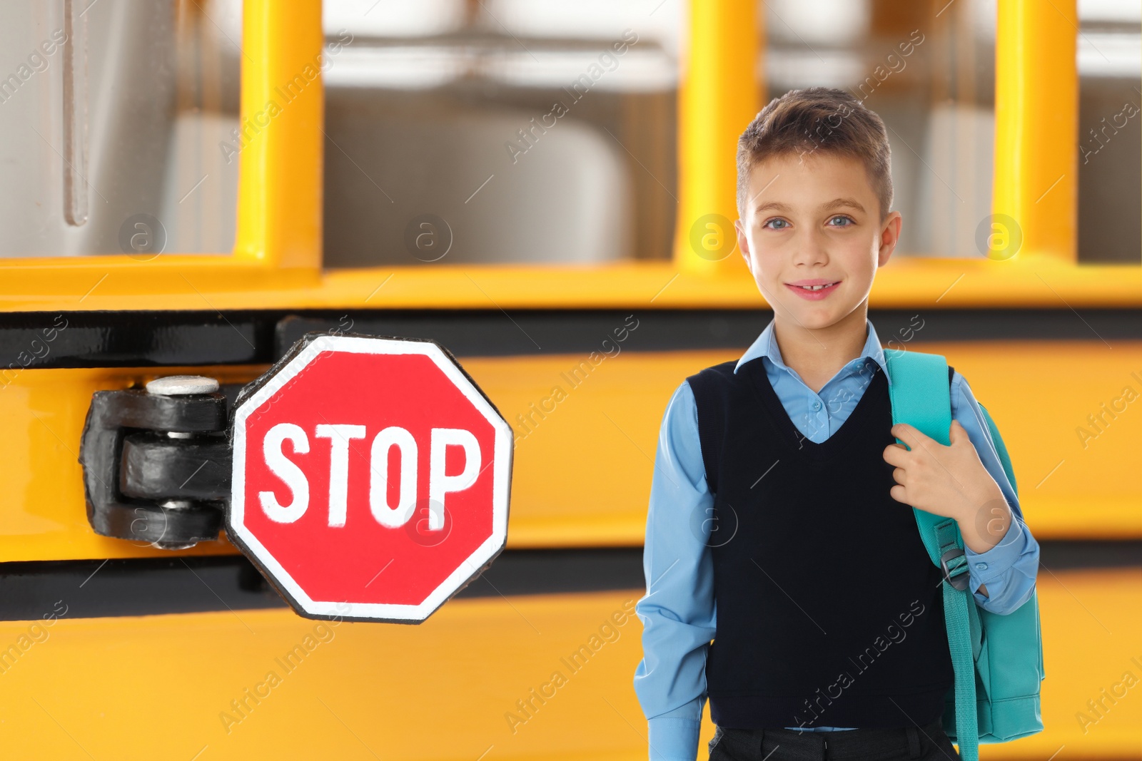 Image of Boy with backpack near yellow school bus. Transport for students