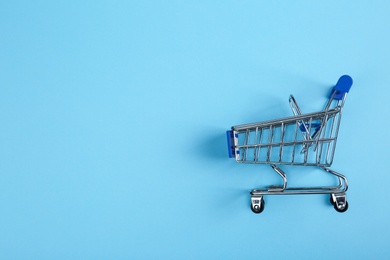 Photo of Empty shopping trolley on color background, top view. Space for text