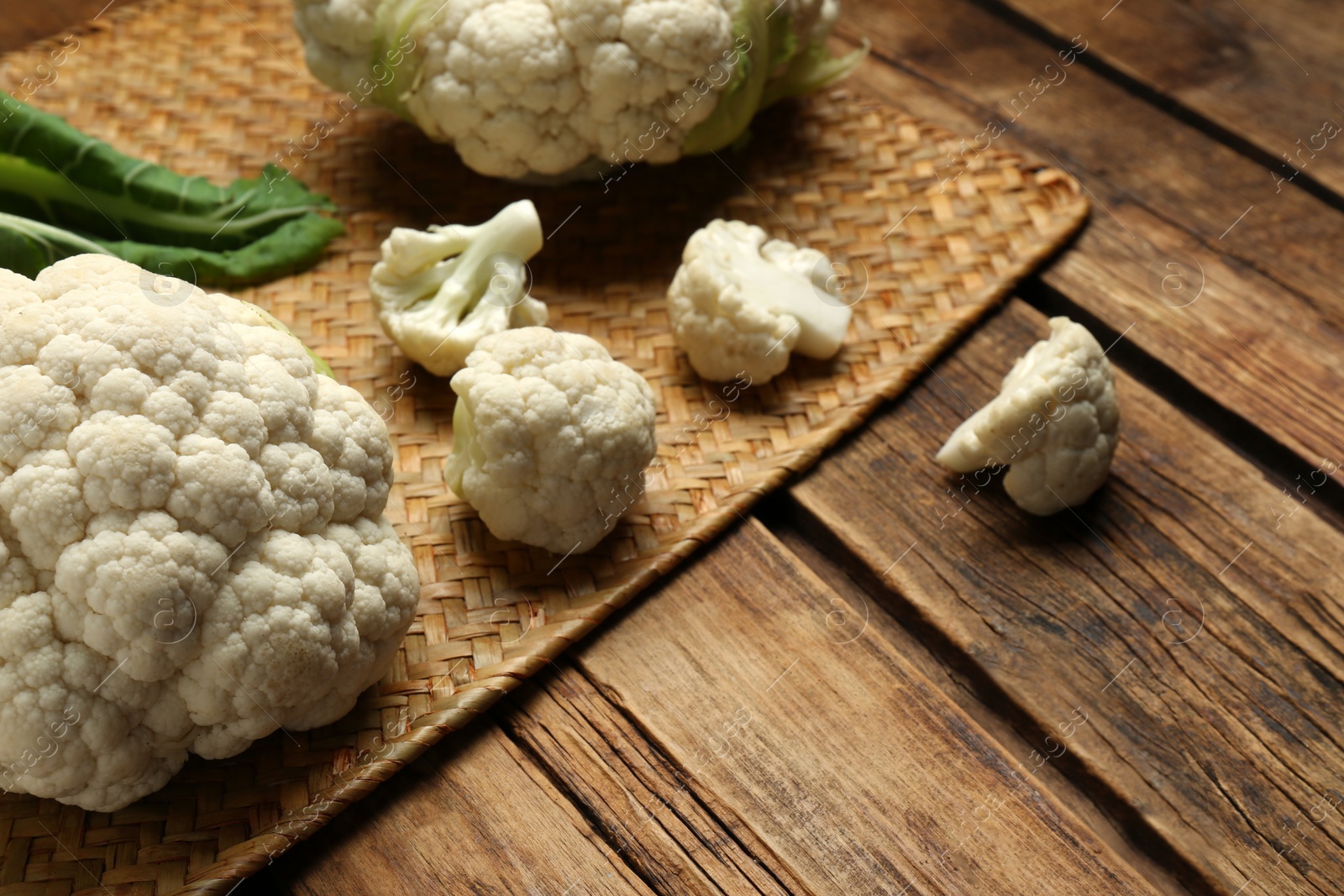 Photo of Fresh cauliflower on wooden table. Space for text