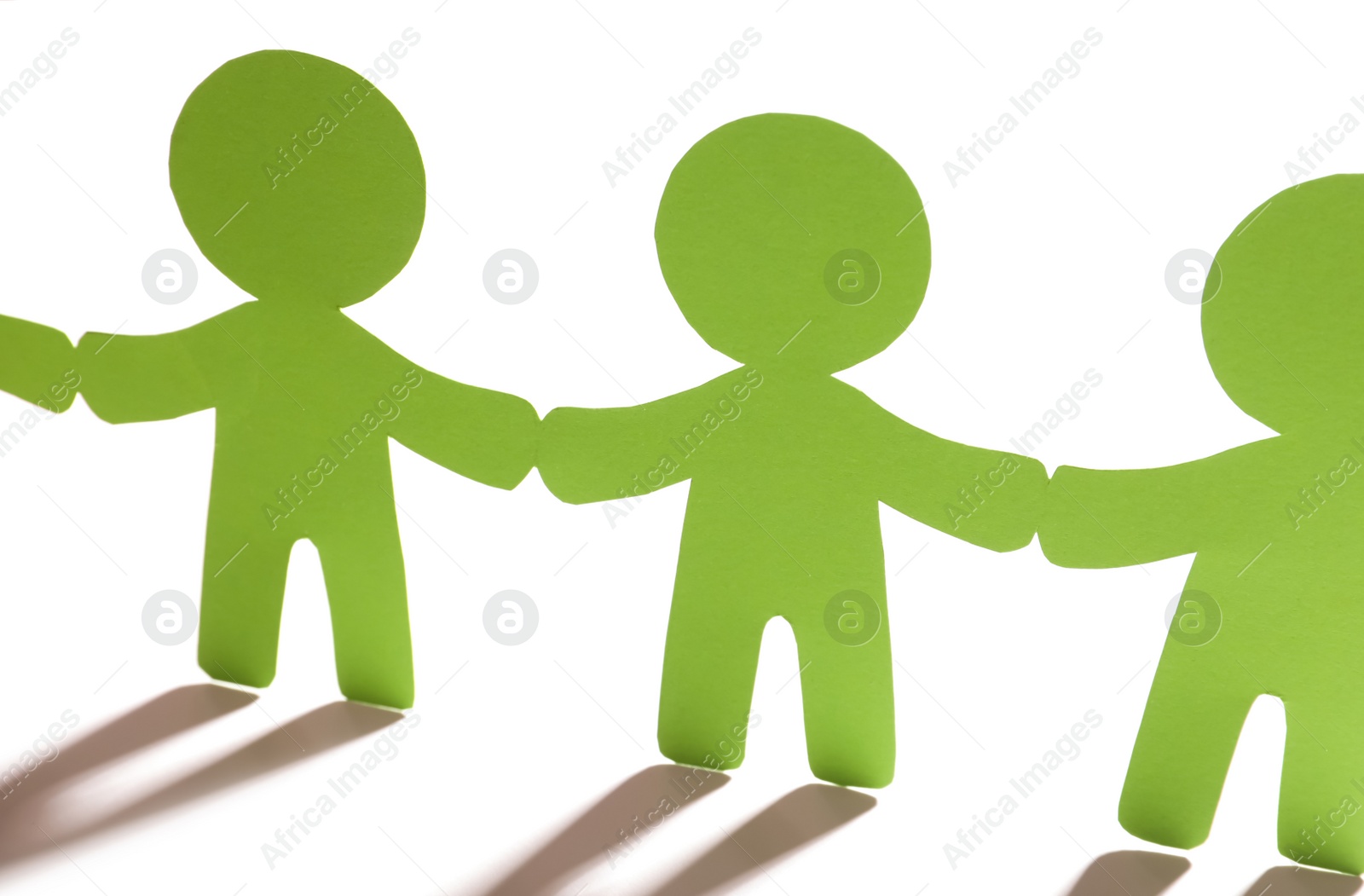 Photo of Paper people holding hands on light background. Unity concept