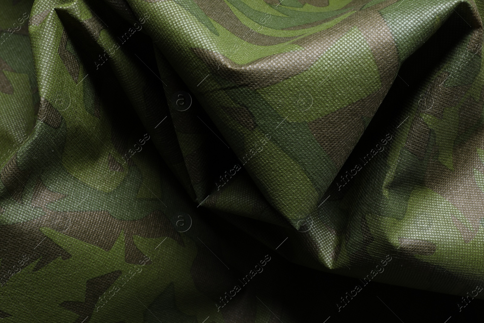 Photo of Texture of crumpled camouflage fabric as background, top view