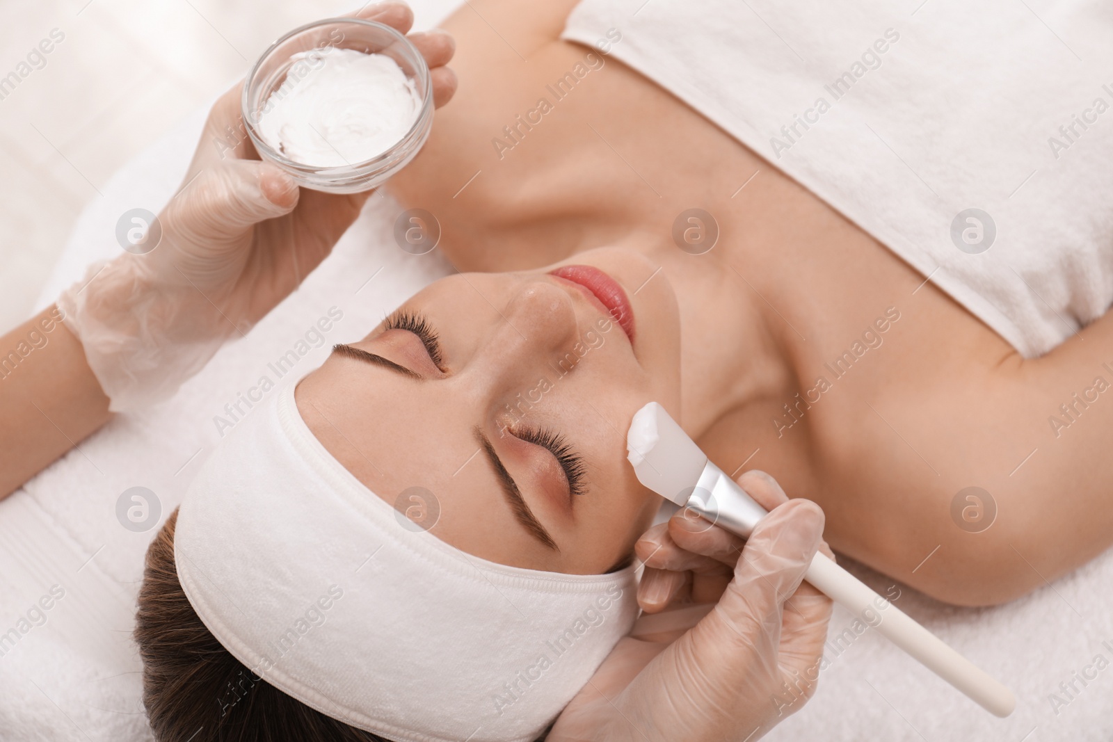 Photo of Young woman during face peeling procedure in salon