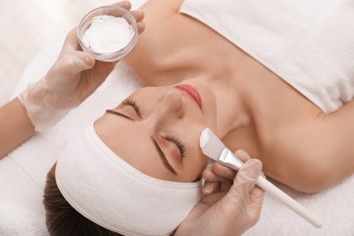 Young woman during face peeling procedure in salon