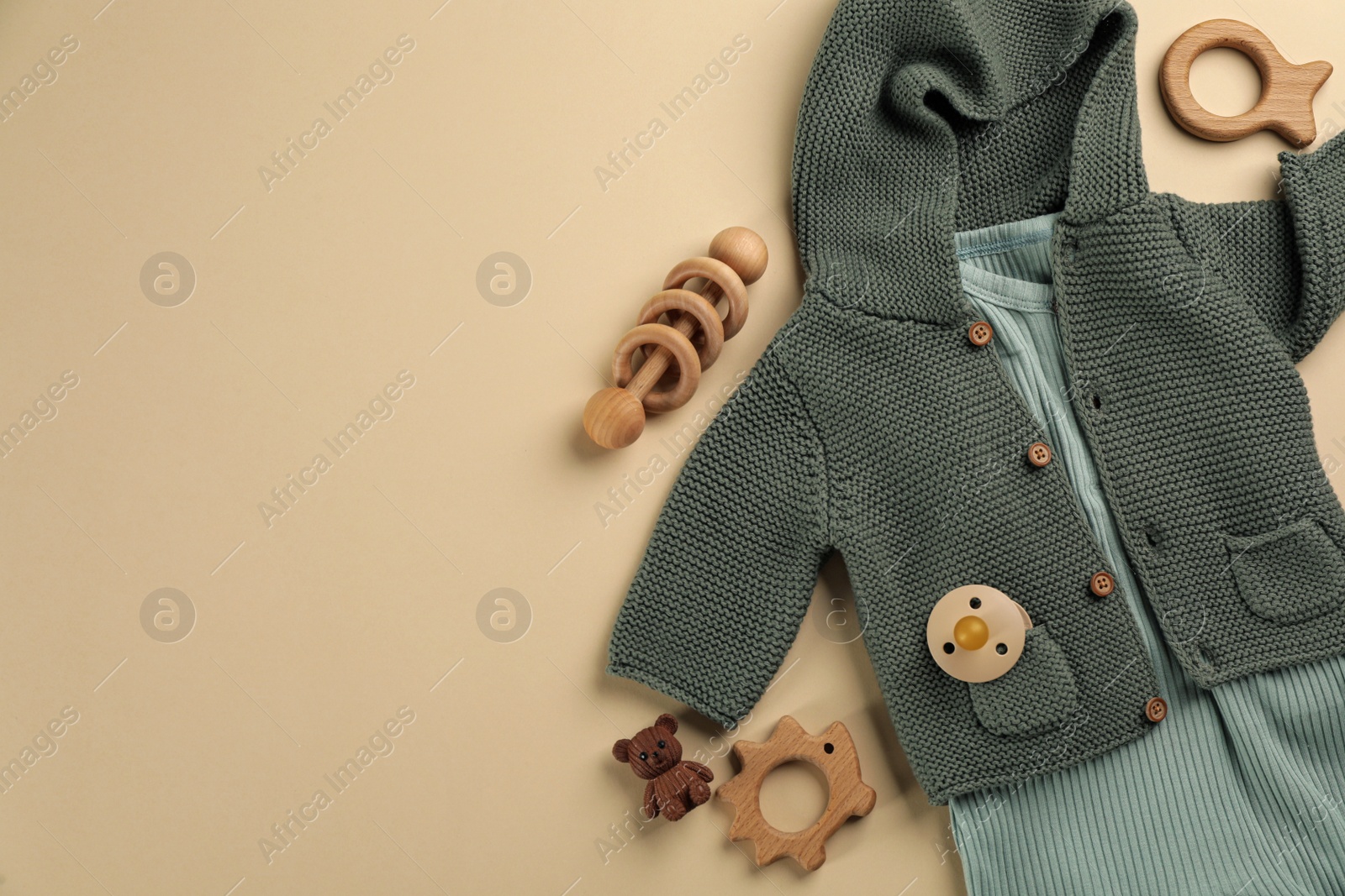 Photo of Flat lay composition with baby clothes and accessories beige background, space for text