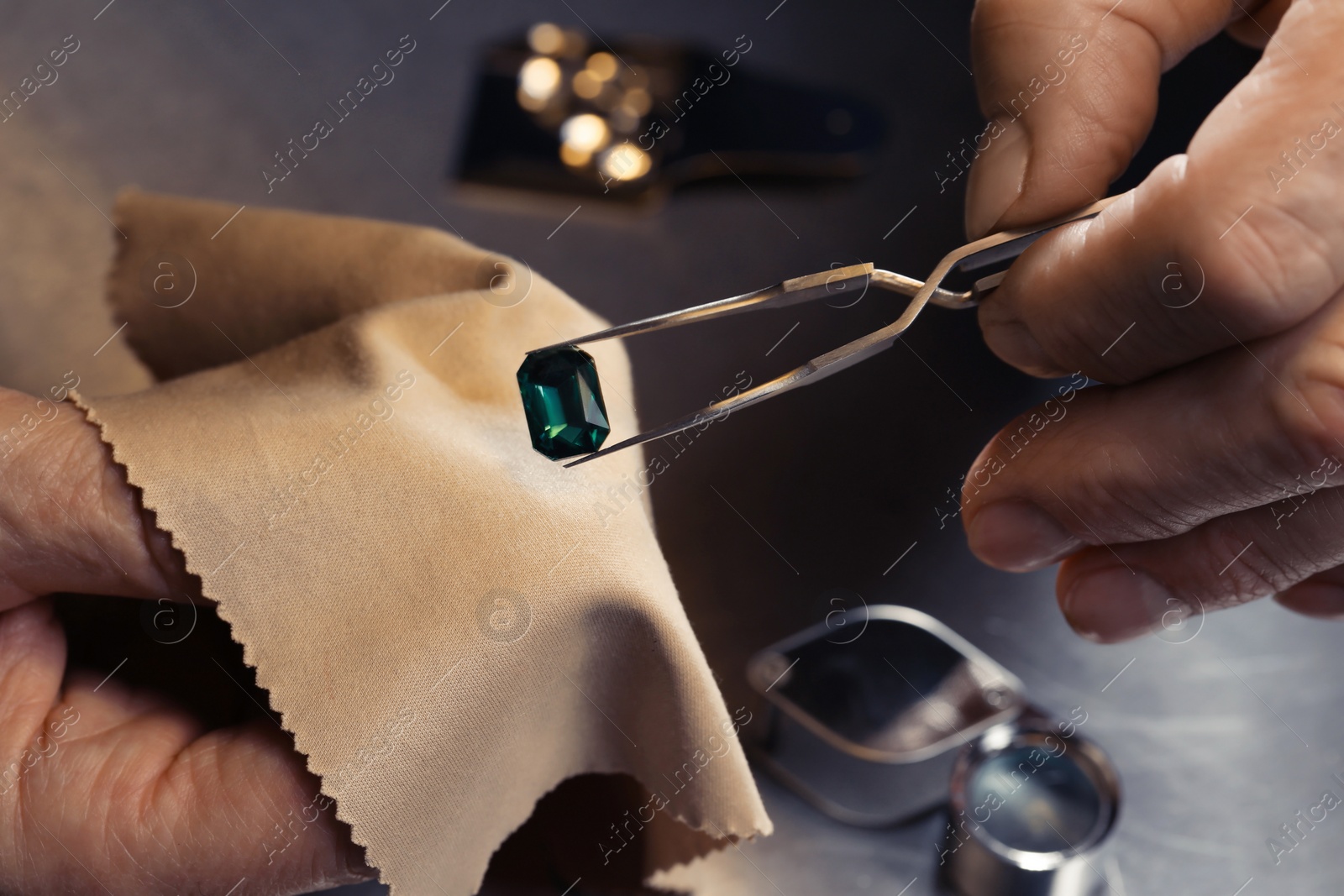 Photo of Professional jeweler working with gemstone, closeup view