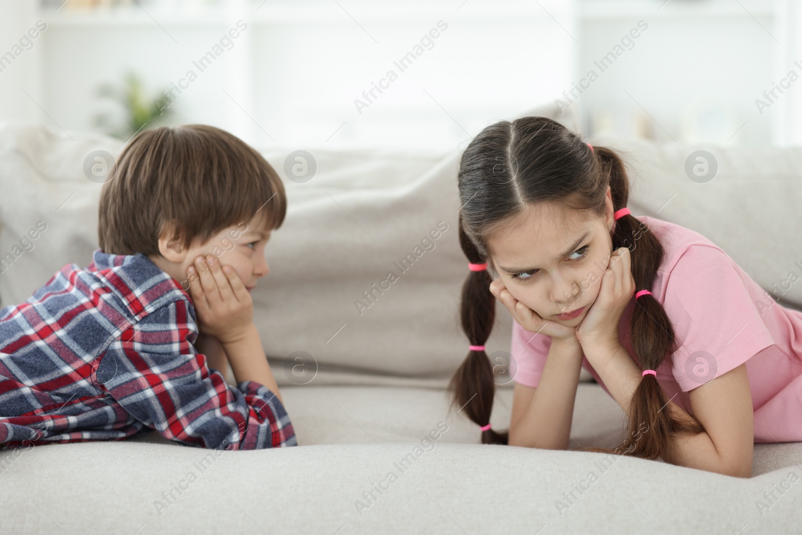 Photo of Upset brother and sister on sofa at home