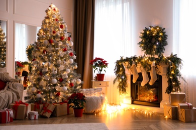 Stylish room interior with fireplace and beautiful Christmas tree